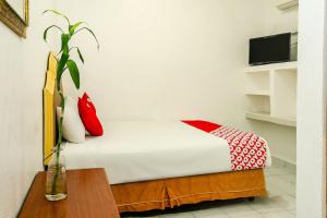 a bed with red and white pillows in a room at OYO Hotel Cabo Del Sur, Cabo San Lucas in Cabo San Lucas