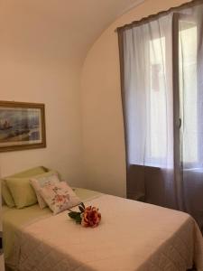 - une chambre avec un lit et une fenêtre fleurie dans l'établissement Romantic Chic Loä, à Loano