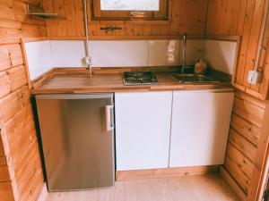 a small kitchen with white cabinets and a sink at Bungalows Rurales Picos de Europa in Posada de Valdeón