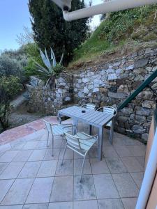 a table and chairs on a patio with a stone wall at Agriturismo Buranco in Monterosso al Mare