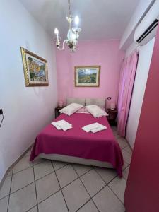 a bedroom with pink walls and a bed with a purple bedspread at Agriturismo Buranco in Monterosso al Mare