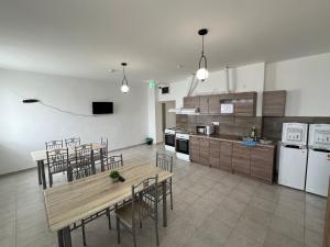 a large kitchen with a table and chairs and appliances at Dream Home in Szentes