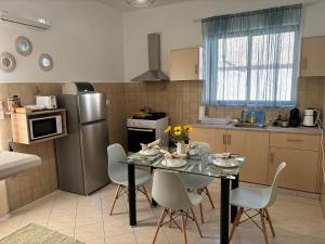 a kitchen with a table with chairs and a refrigerator at V&G Cozy Home near Lindos, Spacious 2BR in vlicha