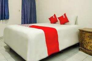 カボ・サン・ルーカスにあるOYO Hotel Cabo Del Sur, Cabo San Lucasの白いベッド(赤い枕付)