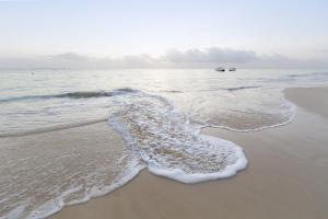 a beach with a wave breaking on the shore at Ko Lanta Hotels and Working Space in Ko Lanta