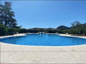 a large swimming pool with blue water at Cozy 2P studio avec jardin privé in Mandelieu-La Napoule