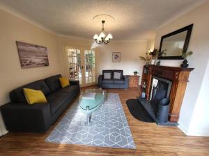 a living room with a couch and a fireplace at Mulberry House in Willsborough