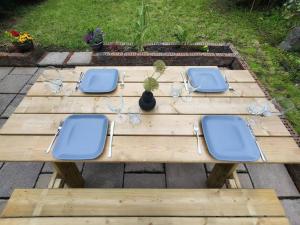 a wooden table with four blue chairs and glasses at Mulberry House in Willsborough