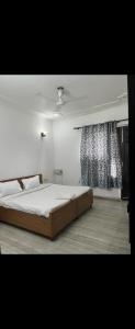 una camera da letto con un letto grande e una finestra di Rising stay a Gurgaon