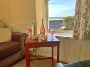 a table with a bottle of wine and two glasses at Finest Retreats - No 62 at Gadlys House in Beaumaris