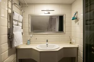 ein Badezimmer mit Waschbecken und Spiegel in der Unterkunft Apart Hotel Michelle in Odessa