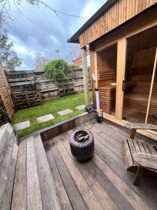 a wooden deck with a fire pit and a bench at Casa Mellow in Ghent