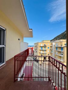 a balcony with a red railing and some buildings at YourHome - Il Pino Rooms & Apartment in Meta
