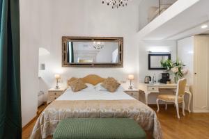 a bedroom with a bed and a desk and a mirror at Palmotta Palace in Dubrovnik