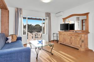 A television and/or entertainment centre at Aparthotel Ona Cala Pi Club