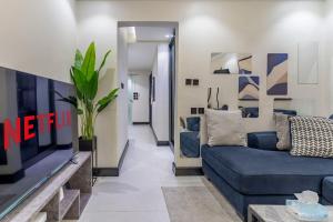 a living room with a blue couch and a tv at استديو فاخر سرير كينج ومطبخ Luxury Studio King Bed in Riyadh