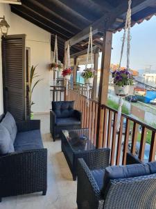 a patio with couches and chairs on a balcony at Sunrise Pefkochori in Pefkohori