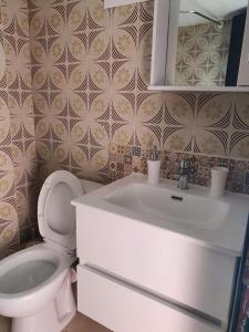 a bathroom with a white sink and a toilet at Sunrise Pefkochori in Pefkohori +18 photos