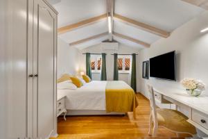 a bedroom with a bed and a desk and a tv at Palmotta Palace in Dubrovnik