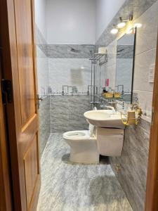 une salle de bains avec toilettes et lavabo dans l'établissement Villa &Coffee Garden, à Xuan An