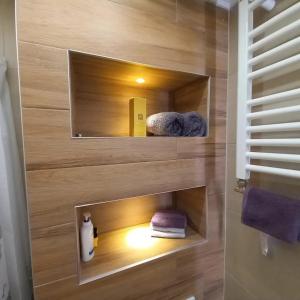 a bathroom with a wooden wall with a mirror and towels at Sarajevo apartman Ilidza Springs parking free in Sarajevo