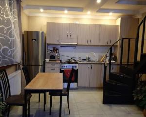 a kitchen with a wooden table and a refrigerator at North Kazbegi in Kazbegi