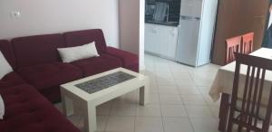 a living room with a red couch and a table at Manoli Apartments in Radhimë