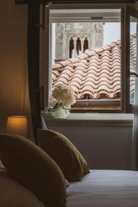 a bedroom with a window and a tiled roof at Palmotta Palace in Dubrovnik