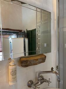 a bathroom sink with a mirror and a bottle of soap at Casa do Olho D'Água in Portalegre