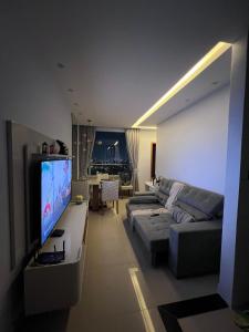 ein Wohnzimmer mit Sofa und Flachbildfernseher in der Unterkunft Castelão Apartment in Fortaleza