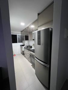 eine Küche mit einem Kühlschrank aus Edelstahl und Arbeitsplatten in der Unterkunft Castelão Apartment in Fortaleza
