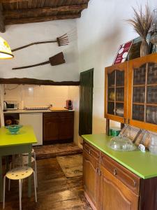 a kitchen with a green counter top and a table at Casa do Olho D'Água in Portalegre