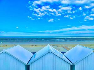 a building on the beach with the ocean in the background at La petite maison rouge in Cucq +10 photos
