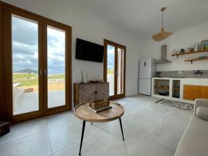 Una sala de estar con una mesa y un refrigerador. en Gaia House, en Kampos