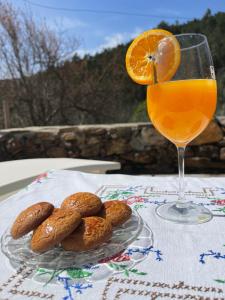a glass of orange juice next to a plate of food at Casa do Olho D'Água in Portalegre +22 photos