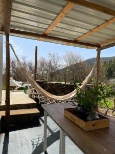 a hammock on a patio with a table and stairs at Casa do Olho D'Água in Portalegre