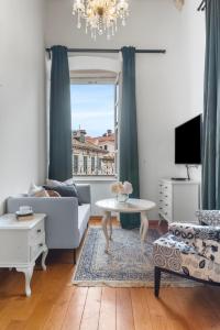a living room with a couch and a table and a window at Palmotta Palace in Dubrovnik