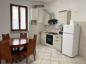 Una cocina con una mesa y un refrigerador blanco. en Flat blue, en Verona