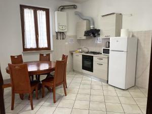Una cocina con una mesa y un refrigerador blanco. en Flat blue, en Verona 19 fotos más