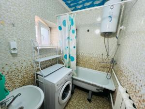a bathroom with a washing machine and a sink at Oroz Guest House in Jangy-Talap