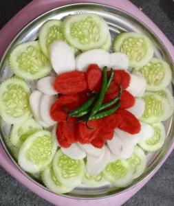 a plate with cucumbers and red peppers and onions at Parvatiya Homestay in Mussoorie +27 photos
