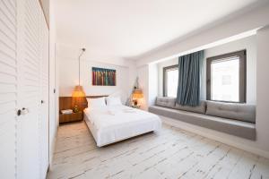 a white bedroom with a bed and two windows at Dione Bozcaada in Bozcaada +143 photos