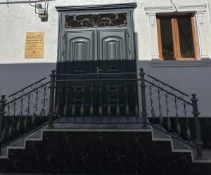 a green door on a white building with stairs at Guest House Bekturdi in Khiva
