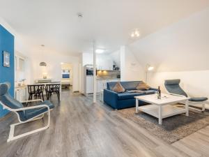salon z niebieską kanapą i stołem w obiekcie Ferienwohnung Meeresbrise in der Residenz Clara Sophia w mieście Binz