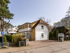 Biały i żółty dom na ulicy w obiekcie Ferienwohnung Meeresbrise in der Residenz Clara Sophia w mieście Binz