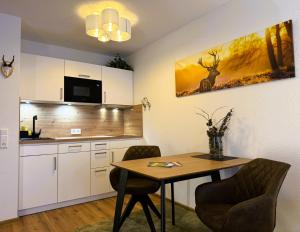 a kitchen with a table and chairs and a kitchen with a counter at Ferienwohnung Seerose Titisee in Titisee-Neustadt