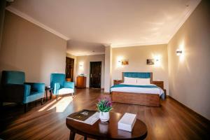 een hotelkamer met een bed, een tafel en stoelen bij Pyramids Oasis Hotel in Caïro