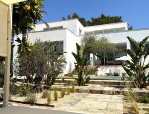 a white house with trees and a swimming pool at Can Toni in Sa Pobla