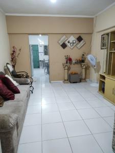 een woonkamer met een bank en een witte tegelvloer bij Casa aconchegante! in Petrolina
