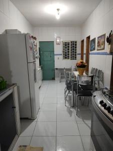 een keuken met een koelkast en een tafel met stoelen bij Casa aconchegante! in Petrolina +3 foto's